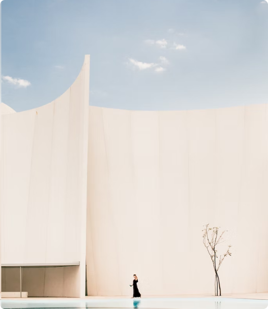 A woman walking in front of a stone building